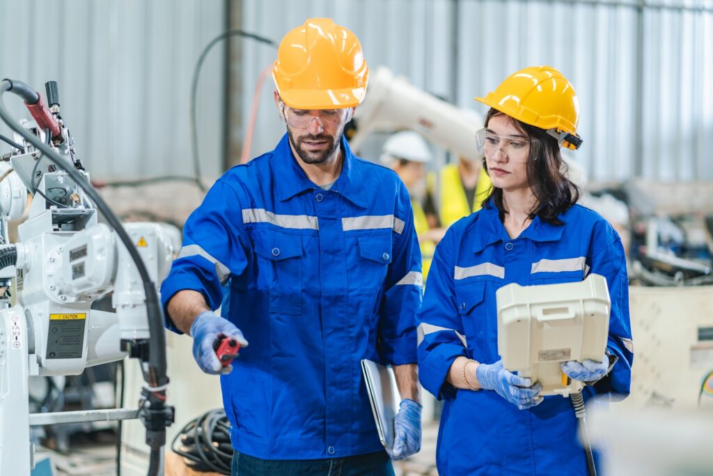 Engineer robot service working in factory, Worker team work to robotic arm software programming