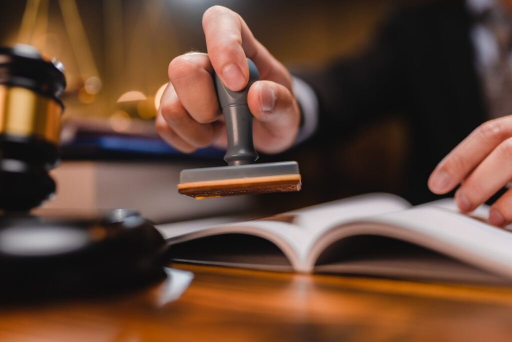 businessman or lawyer put a success stamp on legal deal contract in office, approved on certificate